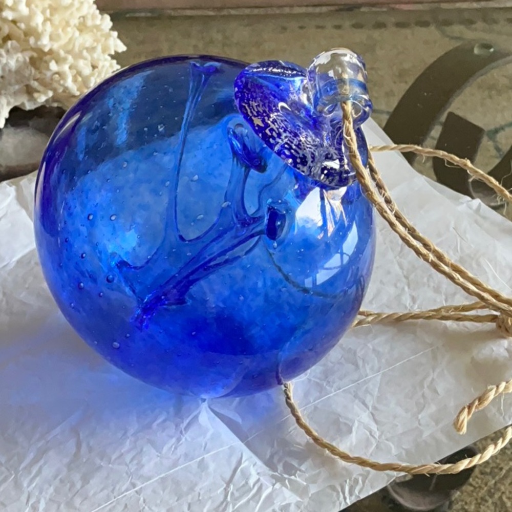 Hand blown vibrant blue ornament with intricate
details.
